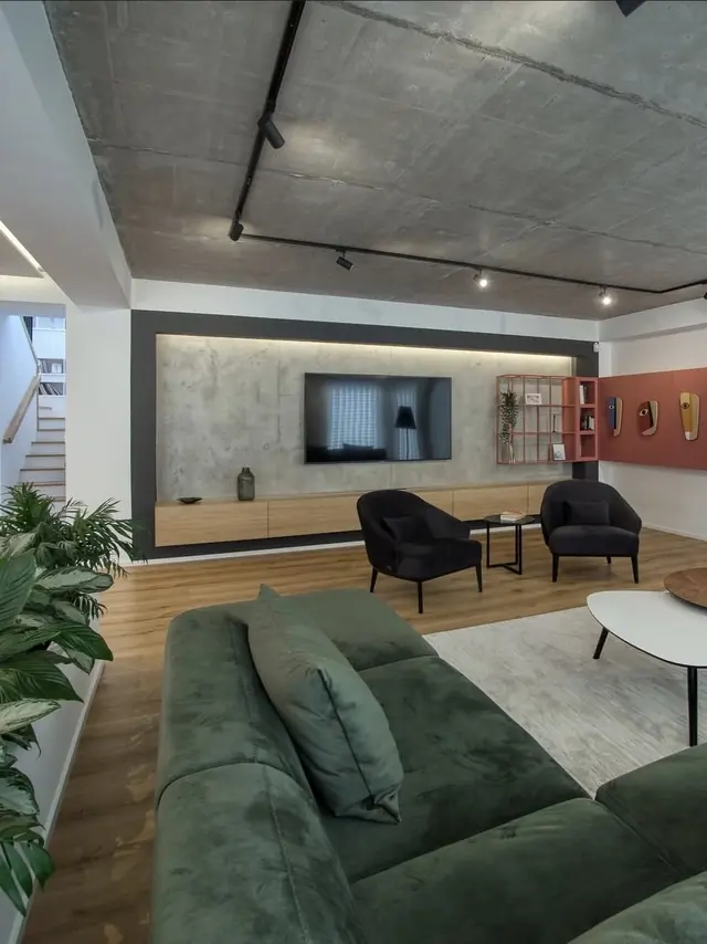 Soggiorno in stile loft con soffitto in cemento e divano verde