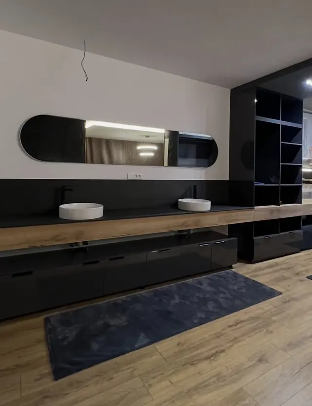 Modernes Badezimmer mit Waschtisch aus Holz und schwarzen Fronten