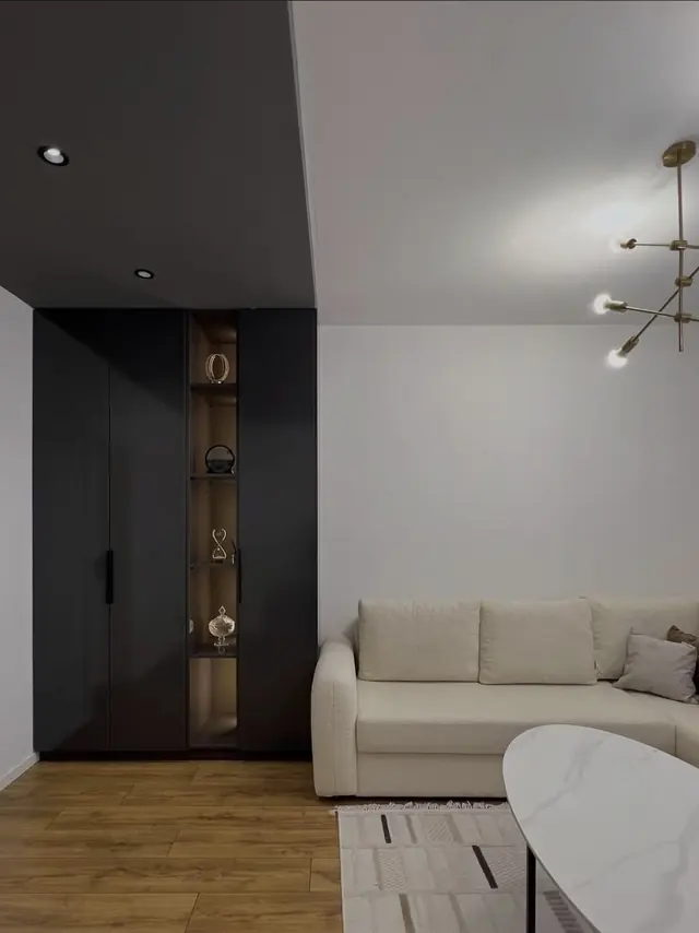 Living room with anthracite wall and lit display cabinet
