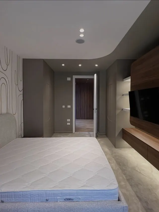 Bedroom in dark tones with wooden TV unit