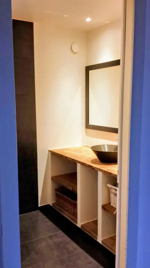 Bathroom with wooden vanity unit and framed mirror