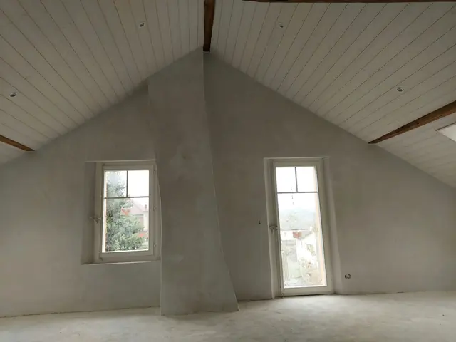 Attic with plastered walls, white panelling and two windows
